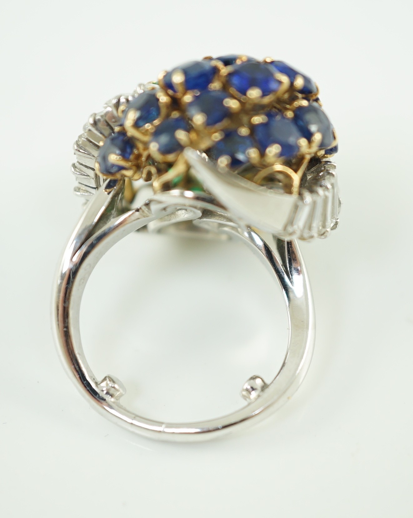 A mid 20th century French 18ct white gold round cut emerald, sapphire and graduated baguette cut diamond cluster set 'Yin-Yang' dress ring, by Mauboussin, Paris